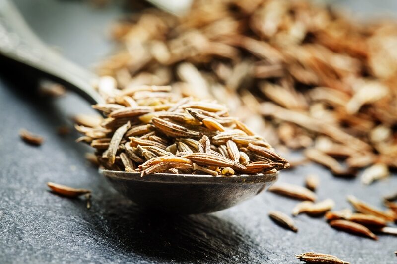 zira-or-cumin-in-a-metal-spoon-on-a-dark-background-close-up-s